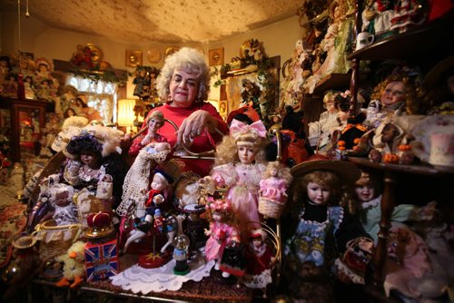 Rozalynde McKibbin is an antique doll collector.  Her home is a museum with over 1000 dolls that she has purchased, been given or she has created herself over her lifetime.   Here McKibbin looks at a display of dolls on a shelf some of which she made like the Princess Diana doll (below her to her right).  See Alex Paul story.  Oct 29, 2015 Ruth Bonneville / Winnipeg Free Press