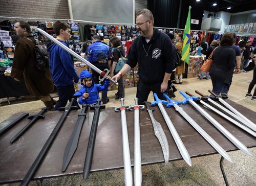 Isaac Loeppky, 5, and dad Dennis check out replica swords at Central Canada Comic Con at RBC Convention Centre Winnipeg on Oct. 31, 2015. Photo by Jason Halstead/Winnipeg Free Press