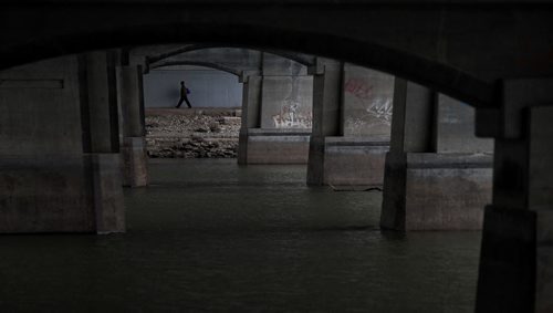 A low Red River flows under the Norwood Bridge Sunday morning while a pedestrian strolls along the underpass walkway.  151101 November 01, 2015 MIKE DEAL / WINNIPEG FREE PRESS