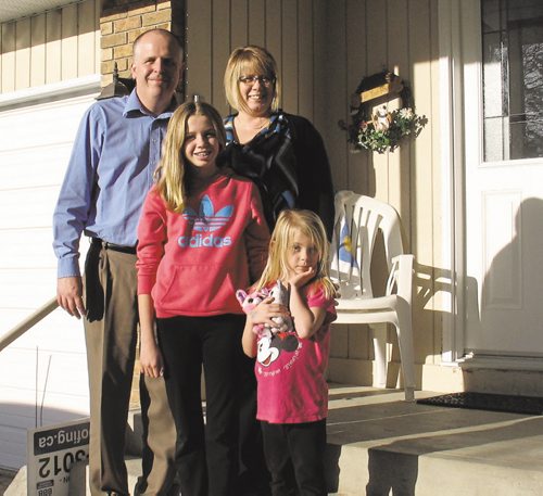 Canstar Community News Peter and Sandra Biesheuvel with their daughters Ella and Laura in front of their North Kildonan home. Laura, 6, is the 2016 Children's Hospital Champion Child. (SHELDON BIRNIE/CANSTAR/THE HERALD)