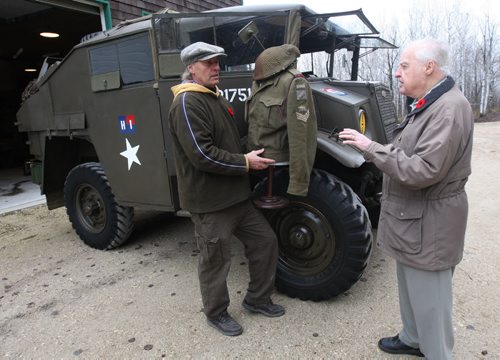 Veteran Stan Butterworth, 91 yrs, left, visits Rob Fast to see his restored 1943 Field Artillery tractor in his yard in Steinbach, Manitoba- Fast shows Butterworth a authentic uniform from the era-See Bill Redekop story Nov 06, 2015   (JOE BRYKSA / WINNIPEG FREE PRESS)