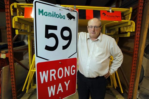 Keith MacCharles, co-owner of Airmaster, says his sign company has been effectively shut out of provincial tendering for highway signs for 20 years. Now speaking out. Poses with a sign. BORIS MINKEVICH / WINNIPEG FREE PRESS  NOV 6, 2015