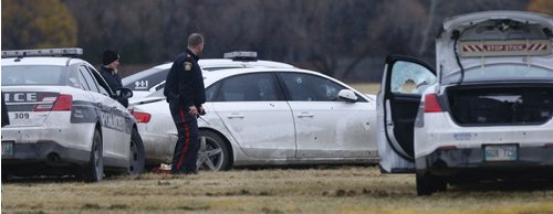 Winnipeg Police surround a vehicle in a field at the NW corner of Grant Ave. and Kenaston Blvd. where the occupant was shot by police Friday afternoon.  Randy Turner story Wayne Glowacki / Winnipeg Free Press Nov. 6   2015