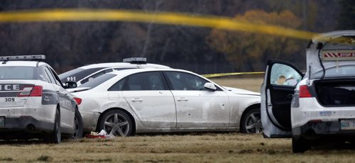 Winnipeg Police vehicles surround a vehicle in a field at the NW corner of  Grant Ave. and Kenaston Blvd. where the occupant was shot by police Friday afternoon.  Randy Turner story Wayne Glowacki / Winnipeg Free Press Nov. 6   2015