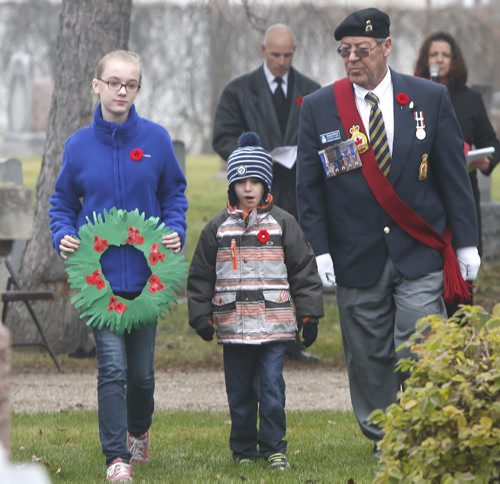 George McCall, Sergeant-At-Arms Elmwood Legion #9 with General Vanier School students Carter Holfield and Jordan Skelly,left, carry  a paper wreath that was made from the handprints of every grade one and grade two students.  They laid the wreath during a Remembrance Day ceremony Tuesday at the Field of Honour section of the Elmwood Cemetery.   Alex Paul story Wayne Glowacki / Winnipeg Free Press Nov. 10  2015