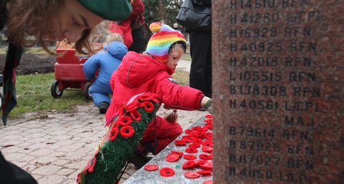 Five-year-old Ollie Cumming places a poppy on a memorial stone  honouring the soldiers who lost their lives in the 1st. and 2nd World Wars while attending the Remembrance Day service Wednesday at Vimy Ridge Park.   Nov 11, 2015 Ruth Bonneville / Winnipeg Free Press
