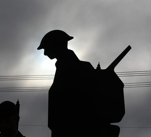 A silhouette of one of the 3 Victoria Cross recipients, (Sargeant-Major Frederick William Hall, Corporal Lionel B. Clarke and Lieutenant Robert Shankland), is backlight by a patch of sunlight amidst the dark clouds during a Remembrance Day service at Valour Road Commemorative Plaza Wednesday.   Nov 11, 2015 Ruth Bonneville / Winnipeg Free Press