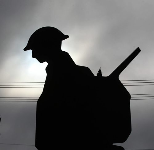 A silhouette of one of the 3 Victoria Cross recipients, (Sargeant-Major Frederick William Hall, Corporal Lionel B. Clarke and Lieutenant Robert Shankland), is backlight by a patch of sunlight amidst the dark clouds during a Remembrance Day service at Valour Road Commemorative Plaza  Wednesday.   Nov 11, 2015 Ruth Bonneville / Winnipeg Free Press