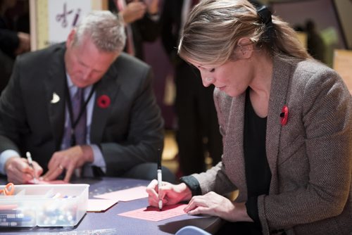 DAVID LIPNOWSKI / WINNIPEG FREE PRESS 151111  The Honourable Mélanie Joly, Minister of Canadian Heritage (right) and President and CEO of the Canadian Museum for Human Rights Dr. John Young, sign letters that will be given to veterans at the museum in Winnipeg on November 11, 2015.