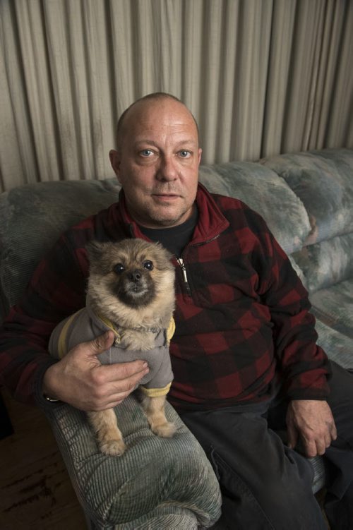 DAVID LIPNOWSKI / WINNIPEG FREE PRESS 151111  Mike Munroe sits with his Pomeranian named Molly at his home November 11, 2015. His cat, Sixx went missing, and he was contacted about the disappearance and scammed out of money hoping to get the cat back.