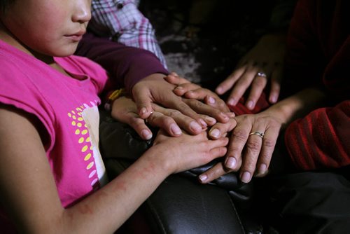 Photos for  Mary Agnes feature piece on CFS, Nelson House First Nation. Illustrated photo of a mother's hands with some of her children surrounding her at their home. The mother has received help from the Wellness Centre and now is back in her home with her children. This mother and her children cannot be identified due to her involvement with CFS.  See story.    Nov 04, 2015 Ruth Bonneville / Winnipeg Free Press