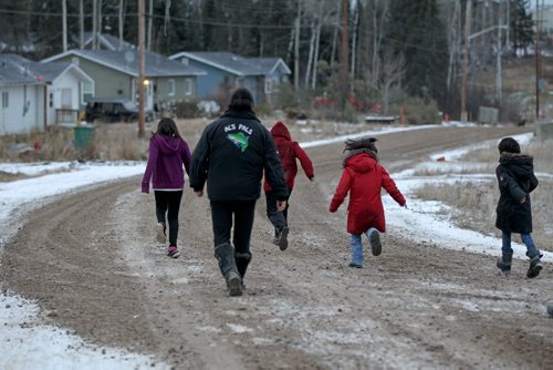 Photos for  Mary Agnes feature piece on CFS, Nelson House First Nation. Photo of mother with her children as they walk along the road in their community.  This mother cannot be identified due to her involvement with CFS.  She has received help from the Wellness Centre and now is back in her home with her children. This mother and her children cannot be identified due to her involvement with CFS.  See story.     Nov 04, 2015 Ruth Bonneville / Winnipeg Free Press