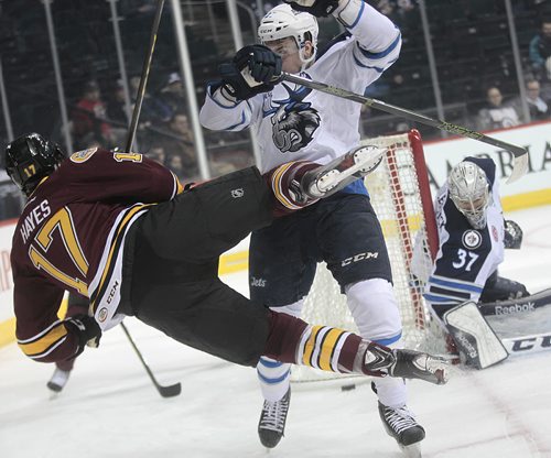 Winnipeg Moose #27 Aaron Harstad sends Chcago Wolves #17 Eriah Haynes airborne and out of the play behind the Moose net THursday evening. See story. November 12, 2015 - (Phil Hossack / Winnipeg Free Press)