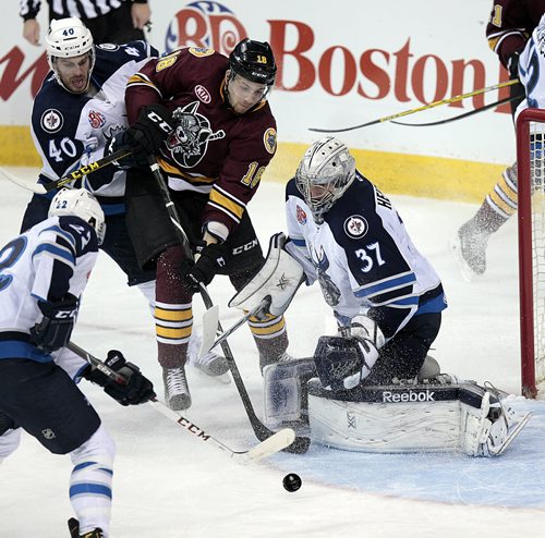 Chicago Wolves #18 works through traffic past Winnipeg Moose #40 Kevin Lynch and netminder #37 Conner Hellebuyck in a second period scoring attempt Thursday. See story. November 12, 2015 - (Phil Hossack)