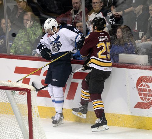 Winnipeg Moose #40 Kevin Lynch slams into the boards with Chcago Wolves #25 Chris Butler in first period action as the puck bounces off the glass in front of them at the MTS Center Friday evening.  November 13, 2015 - (Phil Hossack / Winnipeg Free Press)