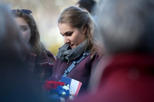 Tingley Douglas (right) and her sister Mairin brought a bouquet of red, white and blue flowers along with a French Flag to the Manitoba legislature Saturday afternoon to a vigil to honour those killed and hurt in the recent Paris attacks.  Both girls had recently lived in France on exchange trips developed close relationships with friends living there. See Kevin Rollason's story.    Nov 14, 2015 Ruth Bonneville / Winnipeg Free Press