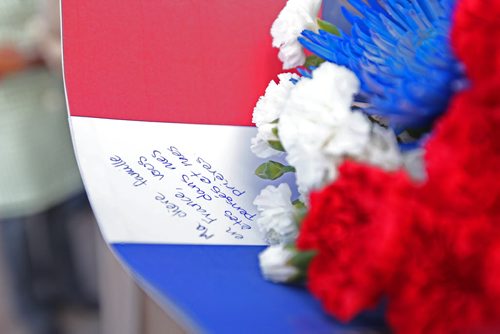 French Honourary Consul Bruno Burnichon is handed a bouquet of red, white and blue flowers along with a French Flag from Mairin Douglas and her sister Tingley  after  vigil for Paris attacks  Saturday afternoon at the legislature.  Both girls had recently lived in France on exchange trips and wanted to come out and support community.   Photo of inscription written on card with flowers.   See story.  Nov 14, 2015 Ruth Bonneville / Winnipeg Free Press