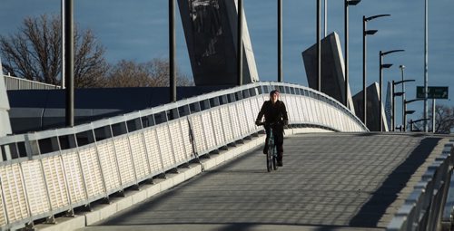 A cyclist makes her way over the Disraeli footbridge early Sunday morning. The forecast is for sunny clear skies and a high of 10C.  151115 November 15, 2015 MIKE DEAL / WINNIPEG FREE PRESS