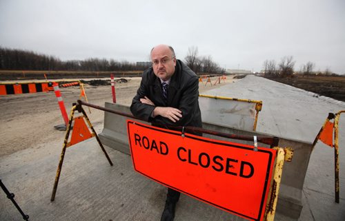 City Councillor Russ Wyatt leans on the road closed sign up at the east end of Reenders road Tuesday.  For story on how it remains closed even though it is finished being built just because Hydro hasn't put in lighting.  See Aldo's story.   Nov 17, 2015 Ruth Bonneville / Winnipeg Free Press