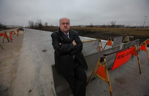 City Councillor Russ Wyatt leans on the road closed sign up at the east end of Reenders road Tuesday.  For story on how it remains closed even though it is finished being built just because Hydro hasn't put in lighting.  See Aldo's story.   Nov 17, 2015 Ruth Bonneville / Winnipeg Free Press