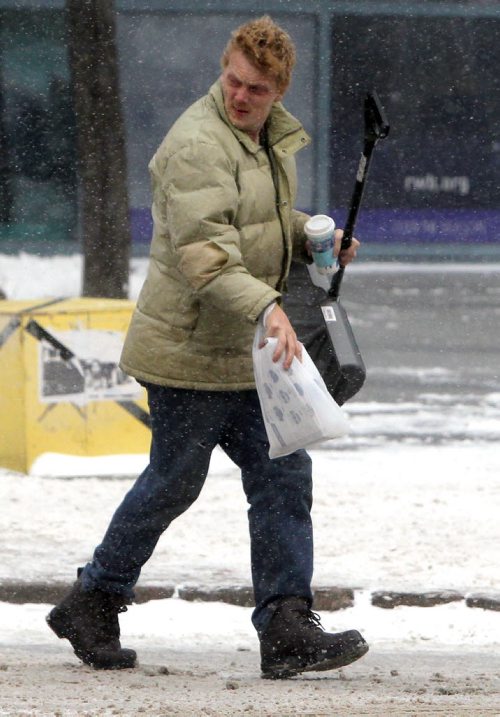 Wicked weather wears on Winnipegers today. An unnamed weather warrior walks with a snow shovel down Edmonton near Graham. BORIS MINKEVICH / WINNIPEG FREE PRESS  NOV 19, 2015