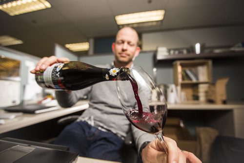 Ben MacPhee-Sigurdson, who has been the Free Press wine columnist for 10 years, tries this year's Beaujolais Nouveau vintage in the newsroom in Winnipeg on Thursday, Nov. 19, 2015.   (Mikaela MacKenzie/Winnipeg Free Press)