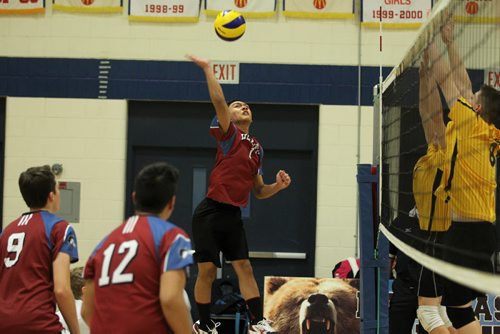 Gabe Cardona (1) with Sturgeon Heights Huskies (red) jumps high for a spike to the Dakota Lancers (yellow)  during the Boys Junior Varsity playoffs at River East Collegiate Thursday evening.   Sports Standup  Nov 19, 2015 Ruth Bonneville / Winnipeg Free Press