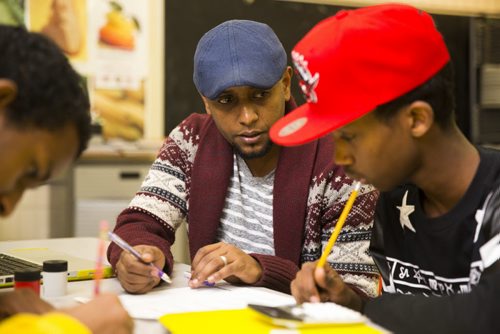 Surafel Kuchem works with newcomer student Zack Awil at the Homework and Education for Youth (HEY) program at Victoria-Albert School in Winnipeg on Friday, Nov. 20, 2015.   (Mikaela MacKenzie/Winnipeg Free Press)