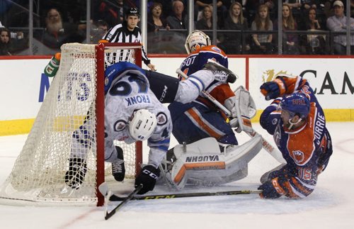 Manitoba Moose Jiri Fronk flips into goalie LAURENT BROSSOIT (31) of  Bakersfield Condors net while Josh Currie (36) of Bakersfield follows during 2nd period AHL action at the MTS Centre Friday night.    Nov 20, 2015 Ruth Bonneville / Winnipeg Free Press