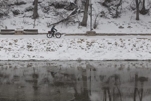 A cyclist drives through the blowing snow on the River Walk along the Assiniboine River early Sunday morning.  November 22, 2015 Mike Deal / Winnipeg Free Press