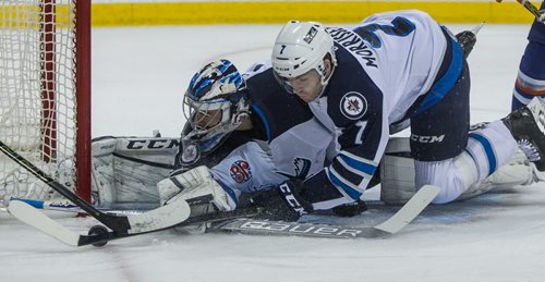 Manitoba Moose' Josh Morrissey (7) falls on top of goaltender Eric Comrie (1) as they dive to deflect the puck during first period AHL action against the Bakersfield Condors at MTS Centre Sunday afternoon. 151122 - Sunday, November 22, 2015 -  MIKE DEAL / WINNIPEG FREE PRESS
