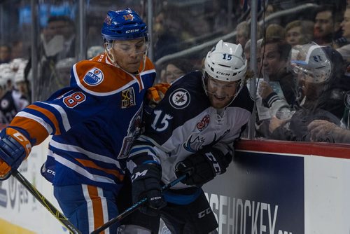 Manitoba Moose' Matt Halischuk (15) is checked against the boards by Bakersfield Condors' Dillon Simpson (18) during first period AHL action at MTS Centre Sunday afternoon. 151122 - Sunday, November 22, 2015 -  MIKE DEAL / WINNIPEG FREE PRESS