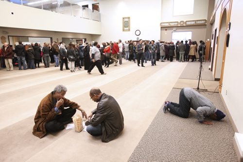 November 22, 2015 - 151122  -  Two men share fellowship and a man prays during an open house at Winnipeg's Grand Mosque Sunday, November 22, 2015.  John Woods / Winnipeg Free Press