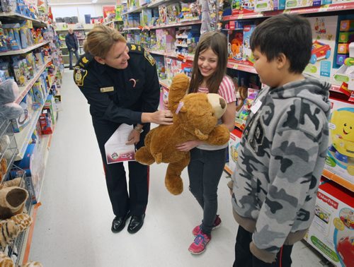 Over 60 Winnipeg Police Service officers took on a role of personal shopper at St Vital Centre today. Armed with Christmas wish lists, the officers were paired up with 60 specially chosen children as part of CopShop.- St. Vital Centre and the WPS along with Louis Riel, Winnipeg One, River East Transcona, St. James-Assiniboia, Division Scolaire franco-manitobaine (Franco-Manitoban School Division) and Pembina Trails School Divisions are joining forces again for CopShop during which each child will receive a $200 gift card donated by St. Vital Centre.- Patrol Sergeant Natalie Aitken spends some time shopping at Walmart with Kayla Fawcett , centre, and Aiden Patrie  from Victoria albert Elementary School-Standup PhotoNov 25, 2015   (JOE BRYKSA / WINNIPEG FREE PRESS)