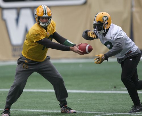 Edmonton Eskimos QB Mike Relly, left,  hands off to Nic Gigsby  at practice at Investors Group Field in Winnipeg The Eskimos will take on the Ottawa Redblacks this Sunday in the Grey Cup Championship-See Ed Tait storyNov 25, 2015   (JOE BRYKSA / WINNIPEG FREE PRESS)