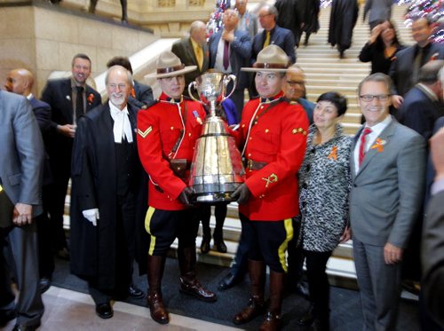 The CFL Grey Cup arrives at the Manitoba Legislature by Red River Cart. Metis , RCMP, and Aboriginal paraded the cup to the Leg in an official event. RCMP Corporals Lester Houle (r) and Rick Sinclair (L) carry the Grey Cup. BORIS MINKEVICH / WINNIPEG FREE PRESS  NOV 25, 2015