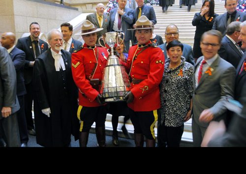 The CFL Grey Cup arrives at the Manitoba Legislature by Red River Cart. Metis , RCMP, and Aboriginal paraded the cup to the Leg in an official event. RCMP Corporals Lester Houle (r) and Rick Sinclair (L) carry the Grey Cup. BORIS MINKEVICH / WINNIPEG FREE PRESS NOV 25, 2015