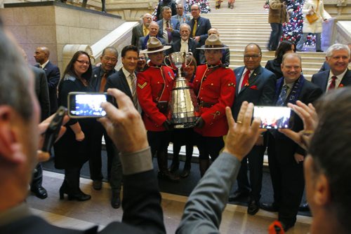 The CFL Grey Cup arrives at the Manitoba Legislature by Red River Cart. Metis , RCMP, and Aboriginal paraded the cup to the Leg in an official event. RCMP Corporals Lester Houle (r) and Rick Sinclair (L) carry the Grey Cup. BORIS MINKEVICH / WINNIPEG FREE PRESS  NOV 25, 2015