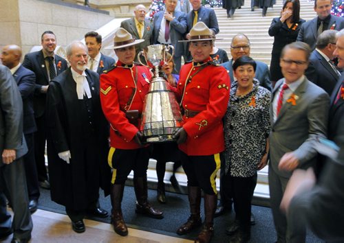 The CFL Grey Cup arrives at the Manitoba Legislature by Red River Cart. Metis , RCMP, and Aboriginal paraded the cup to the Leg in an official event. RCMP Corporals Lester Houle (r) and Rick Sinclair (L) carry the Grey Cup. BORIS MINKEVICH / WINNIPEG FREE PRESS  NOV 25, 2015
