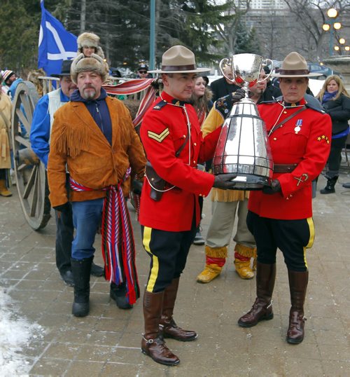 The CFL Grey Cup arrives at the Manitoba Legislature by Red River Cart. Metis , RCMP, and Aboriginal paraded the cup to the Leg in an official event. RCMP Corporals Lester Houle (l) and Rick Sinclair carry the Grey Cup. BORIS MINKEVICH / WINNIPEG FREE PRESS  NOV 25, 2015