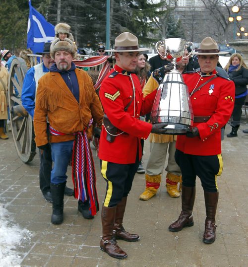The CFL Grey Cup arrives at the Manitoba Legislature by Red River Cart. Metis , RCMP, and Aboriginal paraded the cup to the Leg in an official event. RCMP Corporals Lester Houle (l) and Rick Sinclair carry the Grey Cup. BORIS MINKEVICH / WINNIPEG FREE PRESS NOV 25, 2015