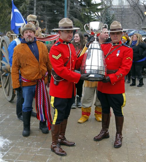 The CFL Grey Cup arrives at the Manitoba Legislature by Red River Cart. Metis , RCMP, and Aboriginal paraded the cup to the Leg in an official event. RCMP Corporals Lester Houle (l) and Rick Sinclair carry the Grey Cup. BORIS MINKEVICH / WINNIPEG FREE PRESS  NOV 25, 2015