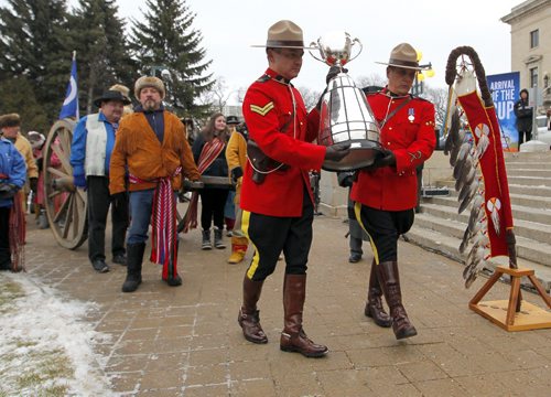 The CFL Grey Cup arrives at the Manitoba Legislature by Red River Cart. Metis , RCMP, and Aboriginal paraded the cup to the Leg in an official event. RCMP Corporals Lester Houle (l) and Rick Sinclair carry the Grey Cup. BORIS MINKEVICH / WINNIPEG FREE PRESS  NOV 25, 2015