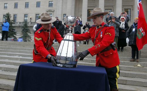 The CFL Grey Cup arrives at the Manitoba Legislature by Red River Cart. Metis , RCMP, and Aboriginal paraded the cup to the Leg in an official event. RCMP Corporals Lester Houle (l) and Rick Sinclair carry the Grey Cup. BORIS MINKEVICH / WINNIPEG FREE PRESS  NOV 25, 2015