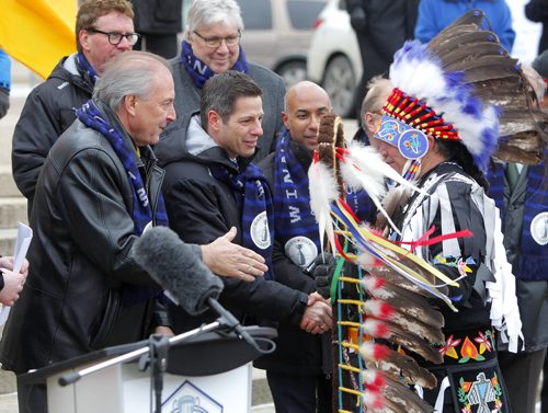 The CFL Grey Cup arrives at the Manitoba Legislature by Red River Cart. Metis and Aboriginal paraded the cup to the Leg in an official event. Here Long Plains first nation Chief Dennis Meeches is greeted by the dignitaries at the event. BORIS MINKEVICH / WINNIPEG FREE PRESS  NOV 25, 2015