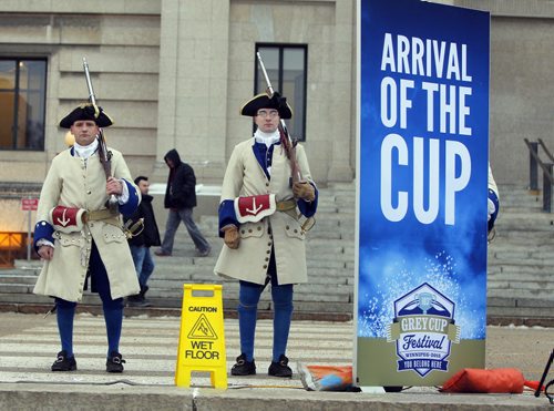 The CFL Grey Cup arrives at the Manitoba Legislature by Red River Cart. Metis , RCMP, and Aboriginal paraded the cup to the Leg in an official event. In the background some period correct actors stand silently and watch the event.  BORIS MINKEVICH / WINNIPEG FREE PRESS  NOV 25, 2015