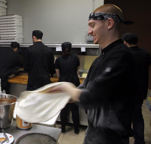 THIS CITY - Santa Ana Pizzeria & Bistro. Alex Kuhn spins some pizza dough in the busy kitchen. BORIS MINKEVICH / WINNIPEG FREE PRESS NOV 25, 2015