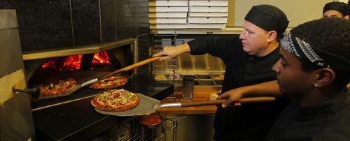 THIS CITY - Santa Ana Pizzeria & Bistro. Owner Darek Wozny (L) and cook Abel Haile (R),  work the wood fired pizza oven. BORIS MINKEVICH / WINNIPEG FREE PRESS  NOV 25, 2015