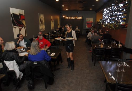 THIS CITY - Santa Ana Pizzeria & Bistro. The decor in the dining room is modern and warm. Server Chelsey Palmer delivers some food to customers.  BORIS MINKEVICH / WINNIPEG FREE PRESS  NOV 25, 2015
