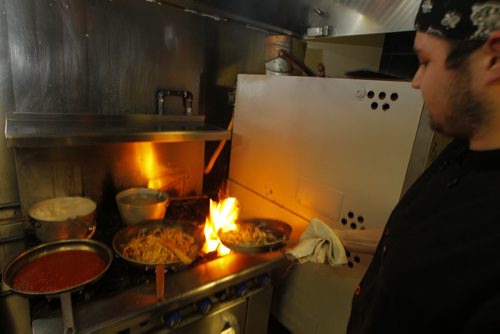 THIS CITY - Santa Ana Pizzeria & Bistro.  Bradyn Palmer is a chef at the restaurant. Here he flames up some food. BORIS MINKEVICH / WINNIPEG FREE PRESS  NOV 25, 2015